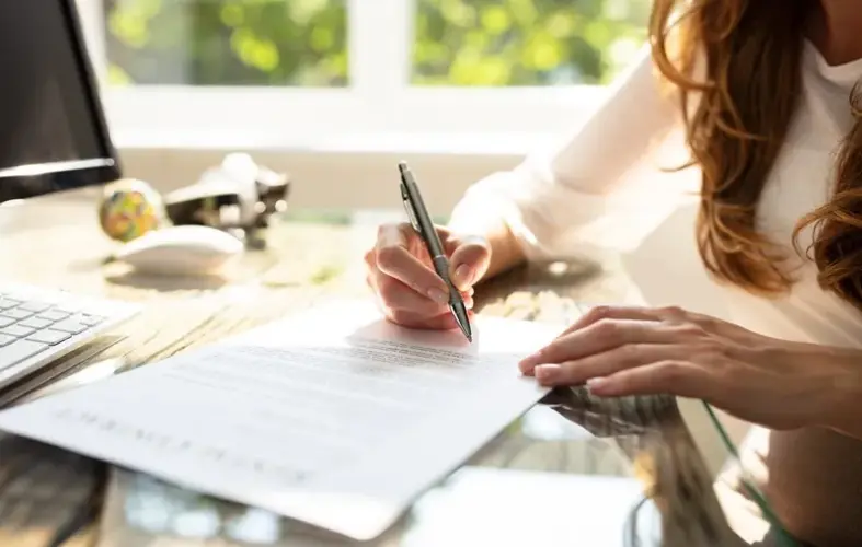 Une femme en train de signer un contrat