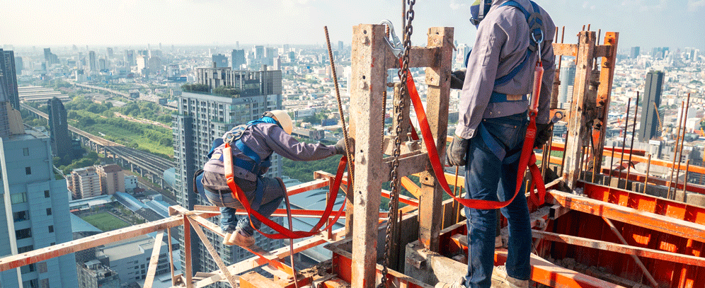 Un Ouvrier Du Bâtiment En Tenue De Travail, Des Gants De Protection  Contient Un Casque Et Un Marteau. Travailler En Haute Altitude. Échafaudage  En Arrière-plan Banque D'Images et Photos Libres De Droits.